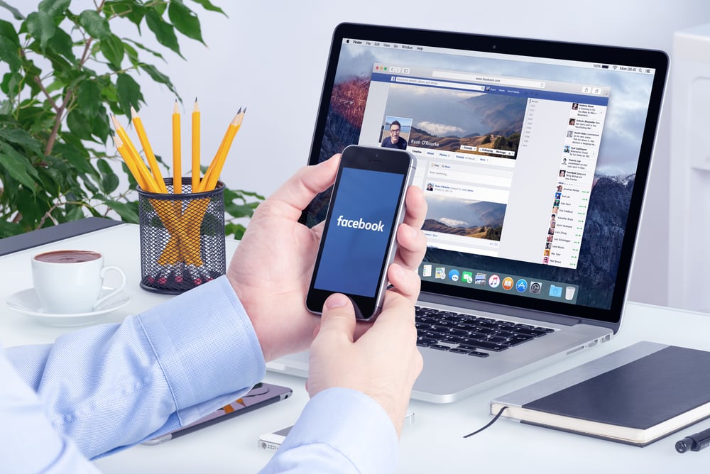 Facebook app on the Apple iPhone display and desktop version of Facebook on the Apple Macbook Pro Retina. Multi devices multitasking concept. All gadgets in full focus. Varna, Bulgaria